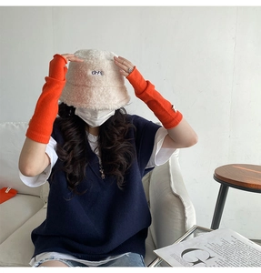 Close-up of bright orange knitted fingerless gloves for warmth while typing and working