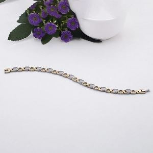Bracciale a maglie a cuore bicolore oro e argento in acciaio inox su sfondo bianco