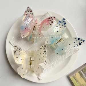 Detailed top view of butterfly hair claws with gradient colors and sparkling rhinestones