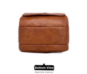 Detailed base view of caramel brown lychee grain leather crossbody bag with wide bottom