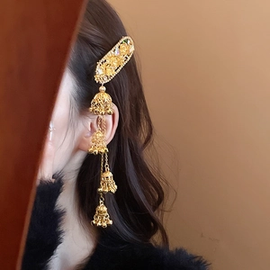 Detailed view of a gold vintage hair clip featuring ornate bells and tassel pendants