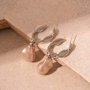 Vintage irregular faux pearl earrings with geometric silver clasp on a stone background