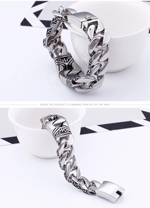 Macro view of men's silver Cuban chain bracelet with vintage totem pattern engraving