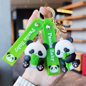 Close-up of cute cartoon panda keychains with green Panda Baby straps and gold rings