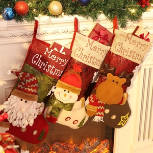 Close-up of three festive Christmas stockings hanging on fireplace with embroidery