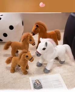 Poupées en peluche de chevaux blanc et marron de différentes tailles sur un tapis doux