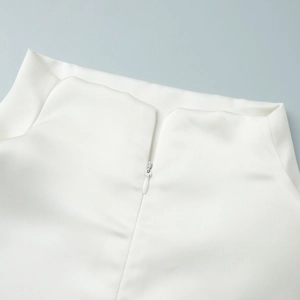 Close-up of invisible zipper and delicate white satin fabric on sleeveless lace top