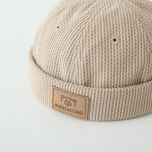 Beige corduroy docker hat for toddlers featuring a leather bear patch and ribbed texture