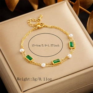 Detail of 18K gold-plated double-layer bracelet with emerald stones and white pearls