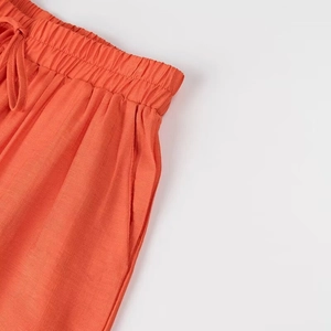 Détail de la taille élastique à cordon et des poches sur ce pantalon côtelé orange