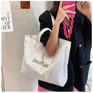 Close-up of white tote bag with Skillfully print and glossy coated texture surface