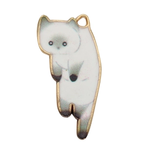 Macro shot of white and light green enamel cat pendant with golden metal edges