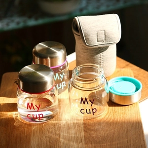 Mini high borosilicate glass jars with metal lids and a fabric pouch on a wooden board