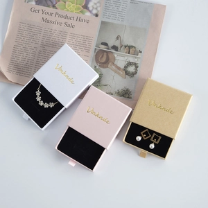 Three drawer jewelry gift boxes in white, pink and kraft paper with golden logo