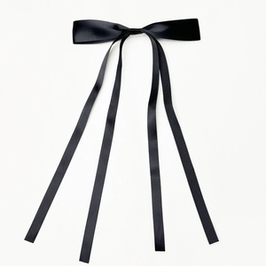 Elegant black satin ribbon bow hair clip with long streamers on white background