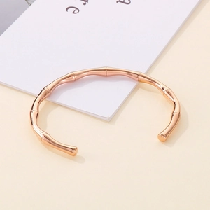 Detailed close-up of rose gold bamboo-style open cuff bracelet with polished finish
