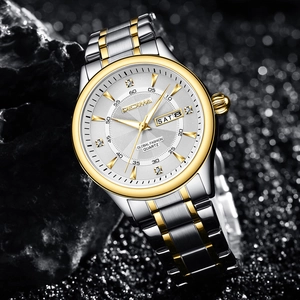 Macro detail of men's two-tone luxury quartz watch on stone with diamond indices and day-date