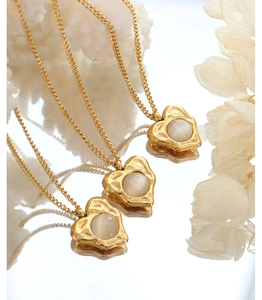 Close-up of gold plated necklaces with heart pendants and white round gemstones