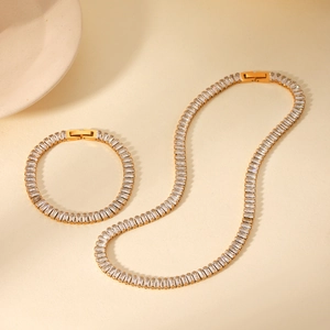 Close-up of gold-plated necklace and bracelet set with baguette-cut cubic zirconia