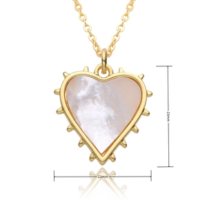 Detail view of heart pendant with white mother of pearl inlay and gold stud edges
