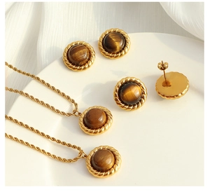 Detailed macro view of vintage tiger eye stone jewelry set on a white ceramic plate