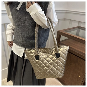 Détails de la couture matelassée dorée et texture brillante sur le grand sac cabas
