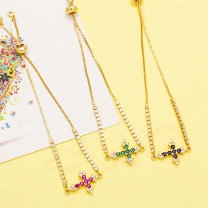 Detail of adjustable cross bracelets with colorful zircon stones in gold finish