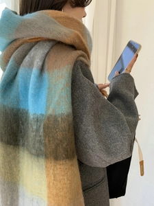 Detailed texture of thick rainbow plaid scarf with fringe and soft cashmere-like fabric