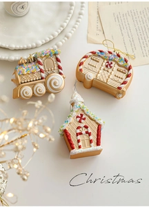 Close-up of glittery Christmas train and gingerbread house ornaments on a holiday table