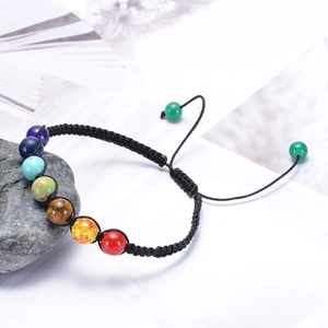 Chakra beaded energy bracelet with natural stones on a stone background for yoga and balance