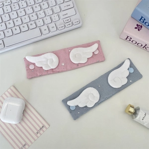 Close-up of pink and grey fabric cable organizers with white plush angel wings and stars