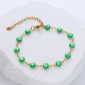 Detail of gold evil eye bracelet with green enamel beads and adjustable lobster clasp