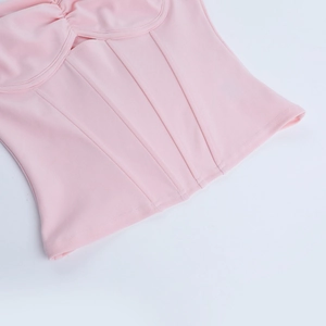 Detail of pink crop top showing ribbing fabric, boning structure and neat stitching quality