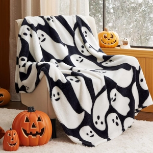 Plush Halloween ghost throw blanket draped over a sofa with festive pumpkin decorations