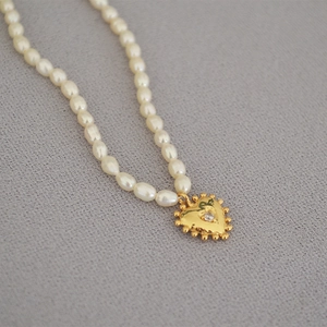 Elegant rice pearl necklace with a vintage gold heart pendant and sparkling zircon stone