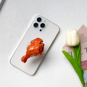 Detailed close-up of a realistic roasted chicken leg phone socket on a white desk