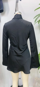 Detailansicht der Rückseite eines schwarzen Satinkleides mit elegantem Glanz und Ärmeln