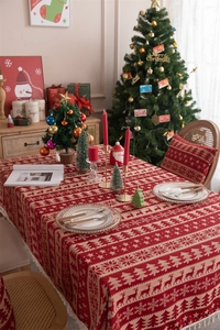 Close-up of woven Christmas tablecloth featuring reindeer patterns and tassel edges