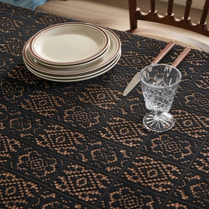 Close-up of black lace tablecloth featuring intricate vintage floral crochet patterns