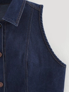 Détail de la veste en jean bleu foncé avec surpiqûres contrastées et boutons en métal