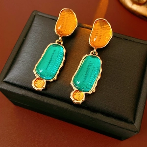 Macro shot of vintage resin earrings with orange and teal geometric color-blocking detail