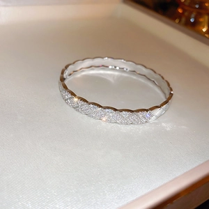 Macro shot of silver bangle featuring quilted lattice design and pave-set zircons
