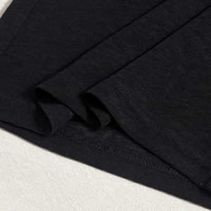 Détail de l'ourlet sur un crop top en tricot noir avec des coutures doubles impeccables