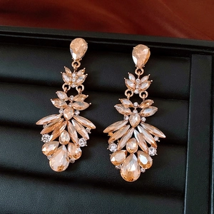 Macro shot of champagne crystal drop earrings with vintage rose gold floral details