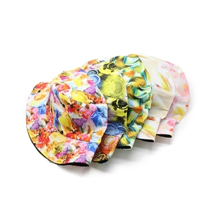 Multiple printed reversible bucket hats with colorful abstract and tropical patterns