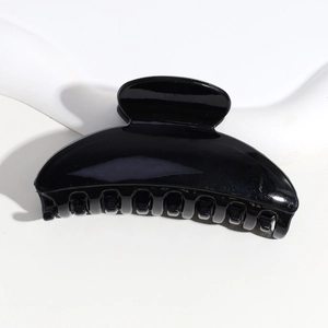 Close-up of minimalist black semi-circular hair claw clip in durable resin material