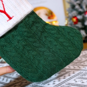 Green knit Christmas stocking with red embroidered letter Y hanging as festive holiday decor