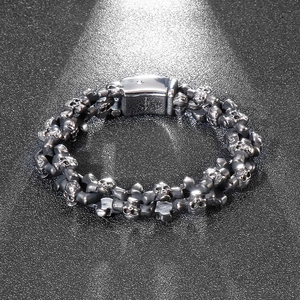 Detailed view of silver gothic skull link bracelet with insertion clasp on black background