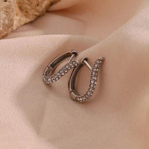Detail of silver U-shaped hoop earrings with micro-pave crystals on pink silk background