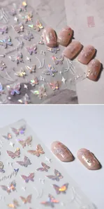 Macro shot of 3D aurora holographic butterfly nail decals on soft pink manicure base